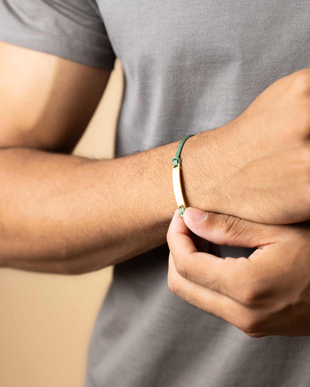 Green nylon bracelet with a gold-plated engraving plate