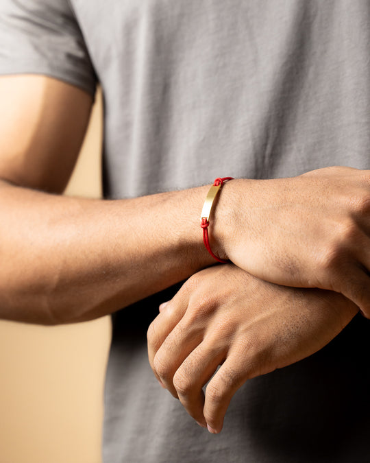 Red nylon bracelet with a gold-plated engraving plate