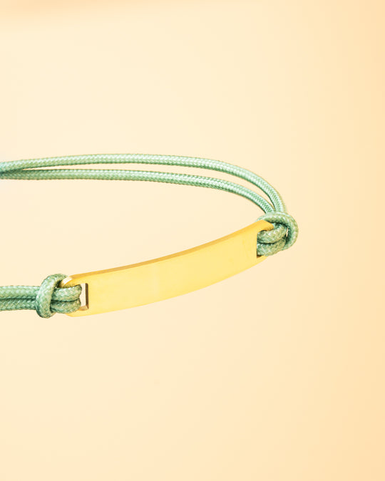 Green nylon bracelet with a gold-plated engraving plate