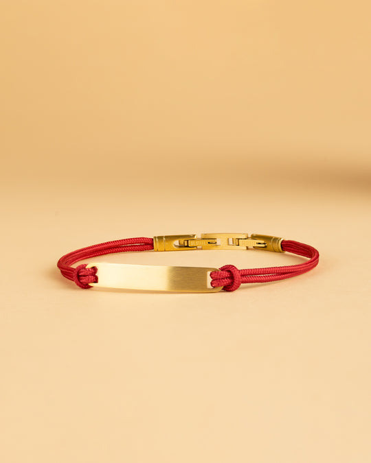 Red nylon bracelet with a gold-plated engraving plate