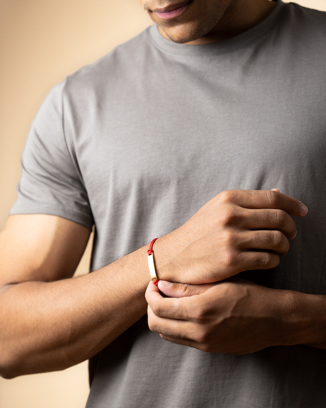 Red nylon bracelet with a gold-plated engraving plate