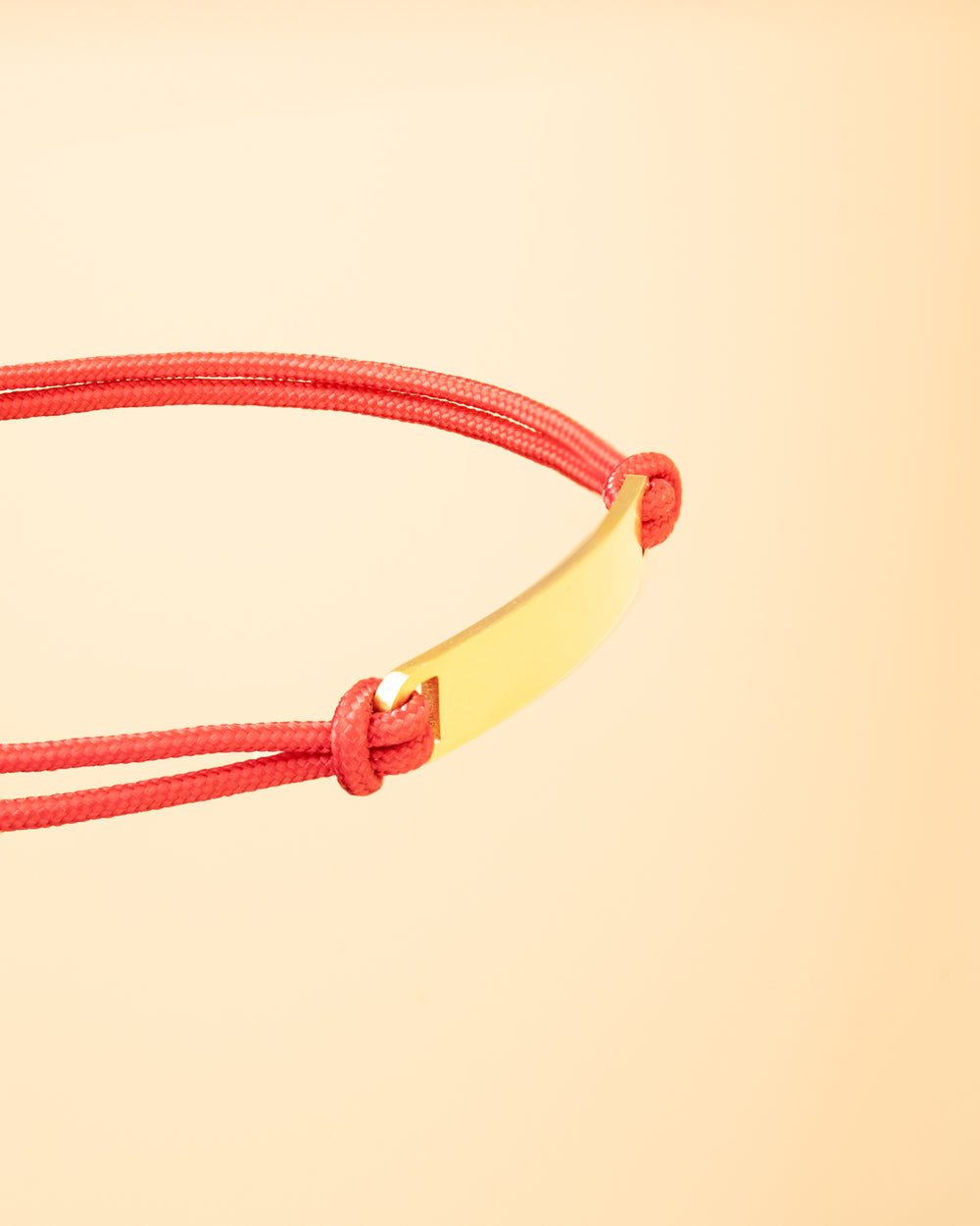 1.5mm red nylon bracelet with a stainless steel closing and gold-plated engraving plate